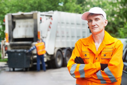 Charity volunteers collecting reusable furniture from a skip